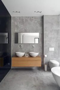 Modern bathroom featuring double sink vanity with concrete walls and floors.