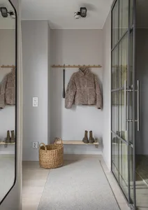 A minimalist entryway with coat hooks and boot storage.
