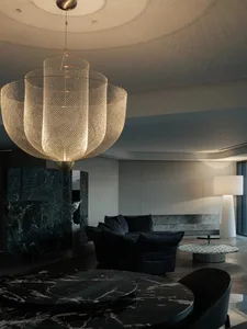 An elegant modern interior designed with marble materials, featuring a chandelier, sofa, and marble tables.