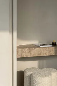 Minimalist living room featuring a stone wall