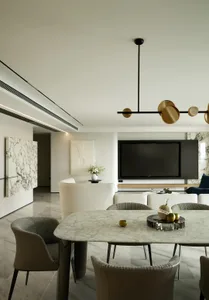A minimalist living and dining room with marble accents and modern furniture.