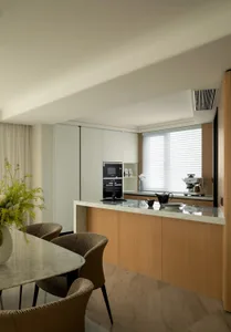 Modern residential kitchen featuring marble countertops and wooden cabinets.