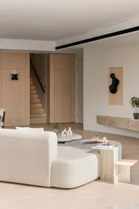 A modern living room featuring a white upholstered sofa, a round concrete side table, and a minimalistic decor scheme.