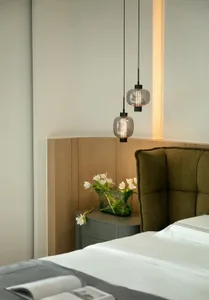 Modern minimalist bedroom with bed, sack lamps and glass vase with tulips