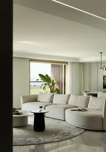 Modern residential living room featuring a comfortable fabric sofa on a stylish marble floor, accented by a sleek glass table