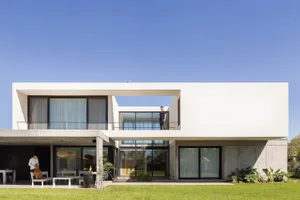 A minimalist house with concrete walls and large windows.