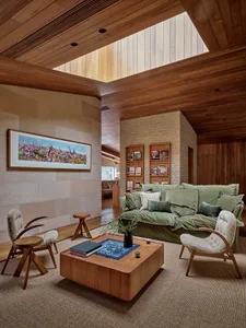 A spacious, modern living room with wooden furniture and a large window.