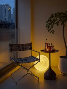 A modern living room featuring a chair with a metal frame and a small table with decorative items.