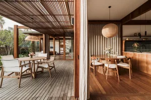 A modern residential dining room featuring wooden furniture and a natural light-filled space.