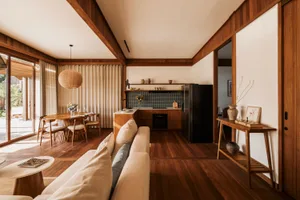 Modern residential interior with concrete flooring, wooden elements, and fabric furnishings.