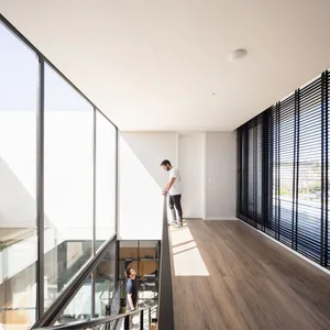 Modern residential interior with large windows, wooden flooring, and metallic accents.