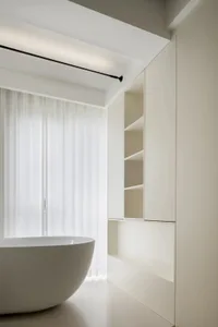 Modern minimalist bathroom featuring ceramic tiles, a freestanding bathtub, and built-in storage
