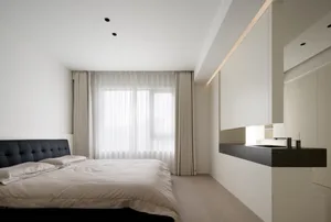 A minimalist bedroom with a large window, white walls, a black bed frame, and wooden flooring.