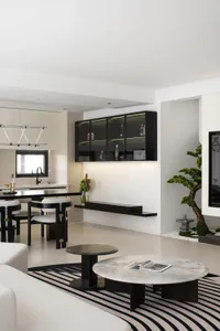 A modern living room featuring a stylish kitchen counter with minimalist black and white design.