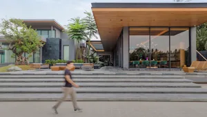 Modern house exterior with concrete, glass, and wooden elements.