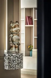Modern interior design featuring a glass bear sculpture with the word 'Jupiter' and an orb pattern base.