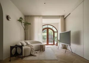 Modern living room featuring cushions, wooden furniture, and glass doors.