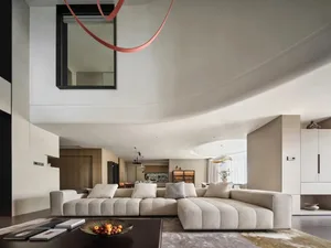 Modern living room with a large beige sectional sofa, a dark wooden dining table, and a sleek, minimalist design featuring so