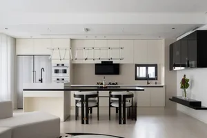 Minimalist kitchen with black countertops and white cabinetry and chairs
