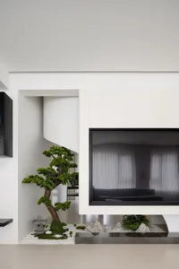 A modern minimalist living room with concrete walls, glass fireplace, and stone accents.