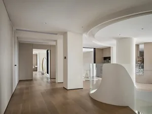 Modern residential interior featuring a hallway with wooden floors, glass railings, and white-cement pillars.
