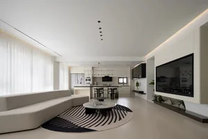 Modern living room with minimalist design, white furniture, and white flooring with a black and white rug.