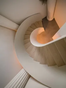 A cozy spiral staircase with wooden steps and a warm, inviting atmosphere.