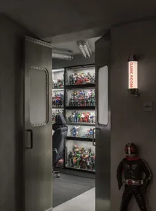 A sleek, industrial-style game room with metallic walls and shelves filled with various action figures.