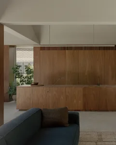 A modern, minimalist kitchen with wooden cabinets and a countertop.
