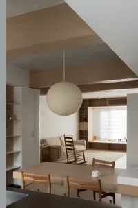 Modern minimalist living room featuring a paper lantern, wood furniture, and concrete walls.
