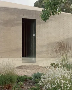 A minimalist modern exterior featuring a concrete and glass façade.