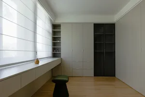 Modern closet with concrete walls and floor tiles, featuring organized storage cabinets and shelves.