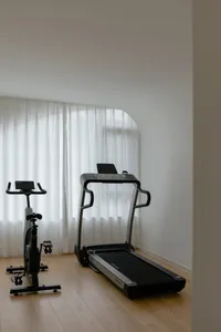 A minimalist home gym featuring exercise equipment and a light-colored floor.