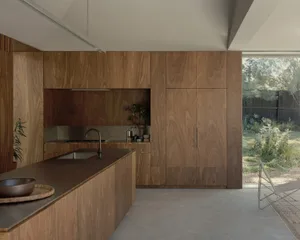 A modern residential kitchen with wooden cabinets and a large island.