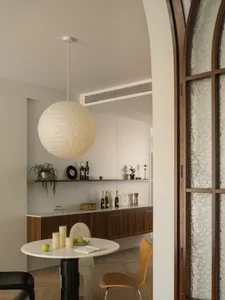 Circular table with wooden chairs in a minimalist residential dining area.