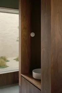 Modern bathroom with wooden cabinets and a white sink.
