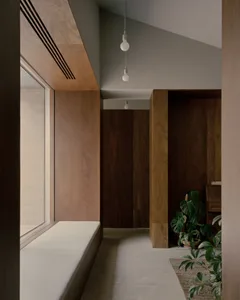 A modern interior space featuring wooden paneling walls and a large window.