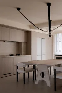 Modern residential kitchen with wood cabinetry, glass backsplash, and stainless steel appliances.