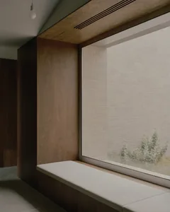 A minimalist residential interior featuring a modern window seat made of wood.