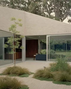 Modern residential exterior featuring sandstone and glass kitchen