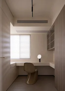 Minimalist workspace featuring a wooden desk and modern chair, suitable for a home office or study area.