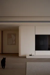 A modern living room featuring concrete walls, marble accents, and wooden flooring.