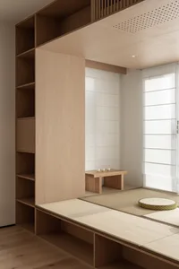 A minimalist living room with wooden furniture and tatami mats on the floor.