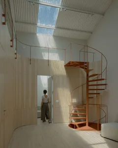 Minimalist house interior featuring a metallic spiral staircase.