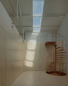 Modern minimalist interior design featuring a metal spiral staircase and wooden walls.