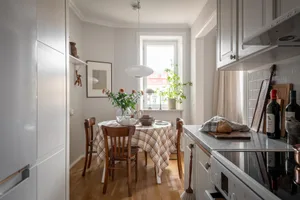 A minimalist kitchen with wood accents and a round table.