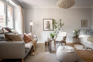 A minimalist living room featuring wooden furniture and fabric accents.