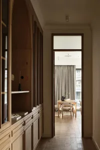 Modern minimalist residential interior with wooden cabinets and glass walls.