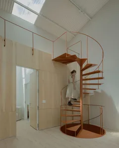 Woman climbing a minimalist metal staircase