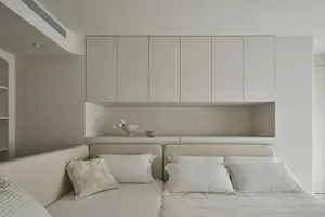 簡約臥室採用混凝土與木質飾面，搭配俐落床鋪與懸浮式層板。